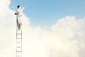 18471869-曇っている背景に対して距離に探している梯子の上に立っている女性実業�